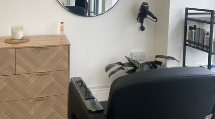 Modern KOZY salon interior in Hindley, England, GB showcasing sleek design with a styling chair and products.