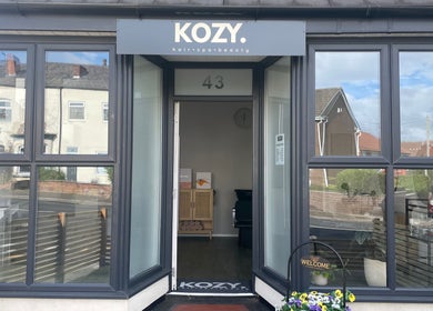 Entrance of KOZY. beauty venue in Hindley, England, GB with large windows and welcoming decor.