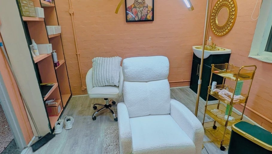 Comfortable treatment room at BROWSByLarna in Redditch, England, GB with luxurious white seating and gold accents.