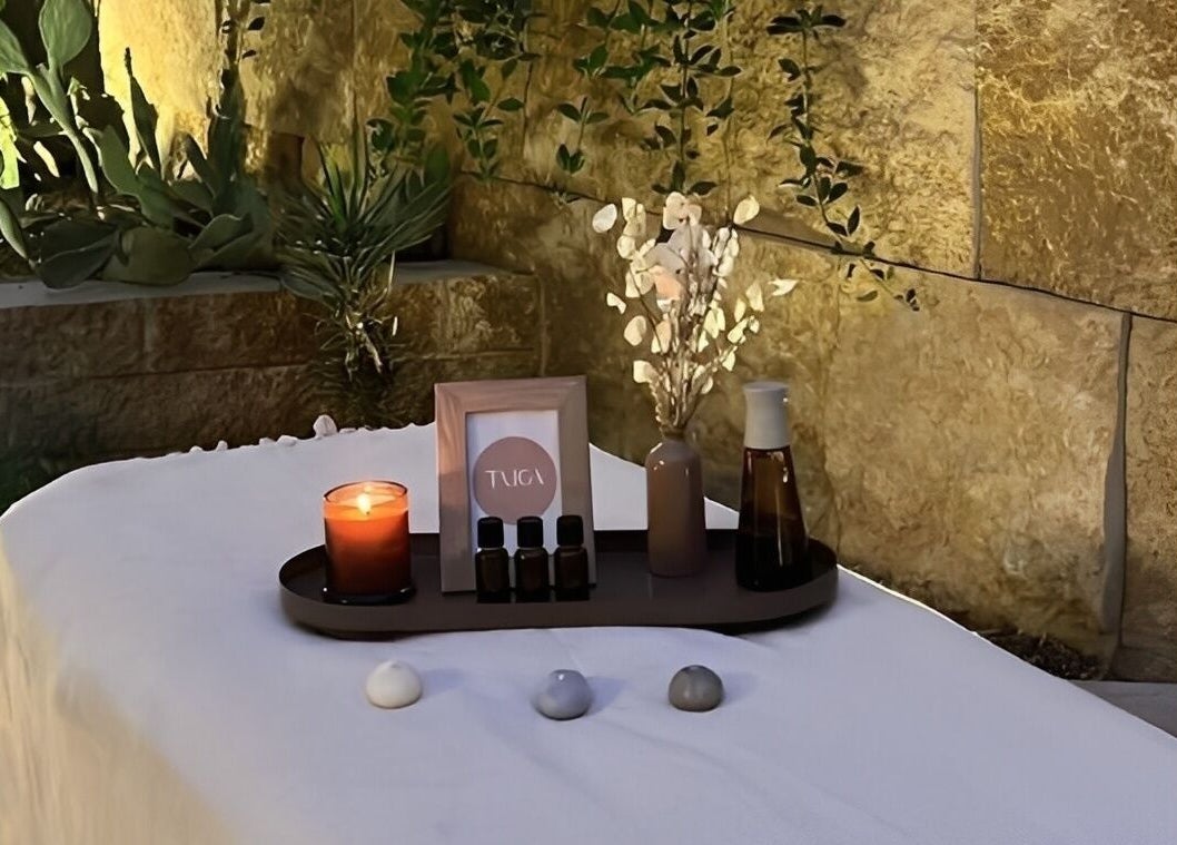 طاولة تدليك في Taiga Spa في الرياض، منطقة الرياض، SA، مزينة بشموع ومواد طبيعية.