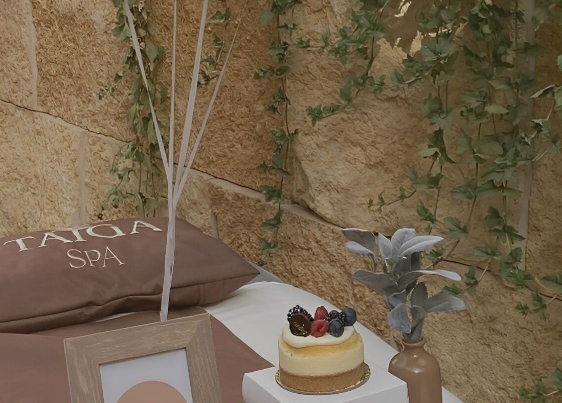 سرير مريح مع وسائد وباقة زهور في Taiga Spa, الرياض، منطقة الرياض، السعودية.