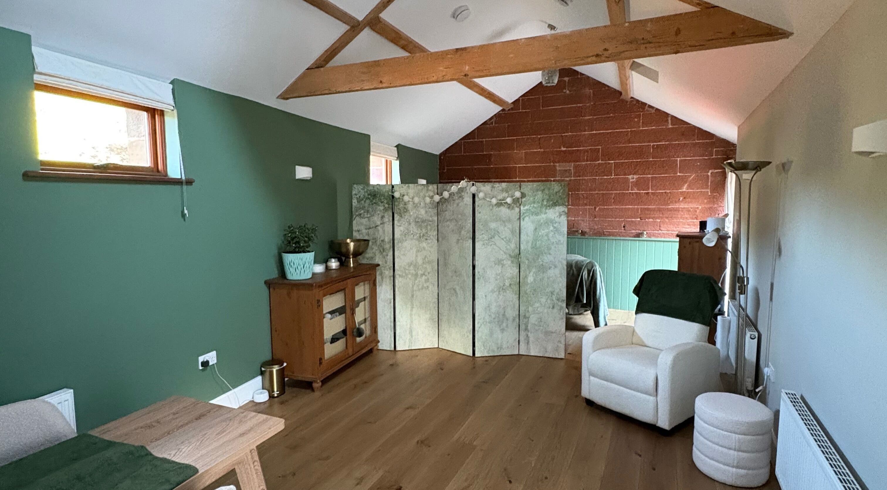 Relaxing wellness space at Feathers Health & Beauty in Dalston, England, GB with green walls and cozy seating.