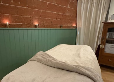 Cozy treatment room at Feathers Health & Beauty in Dalston, England, GB with ambient lighting and relaxing decor.