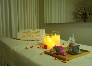 تظهر غرفة استرخاء في مركز Alahd Beauty مع شموع وزهور على طاولة في جدة, مكة المكرمة, SA.