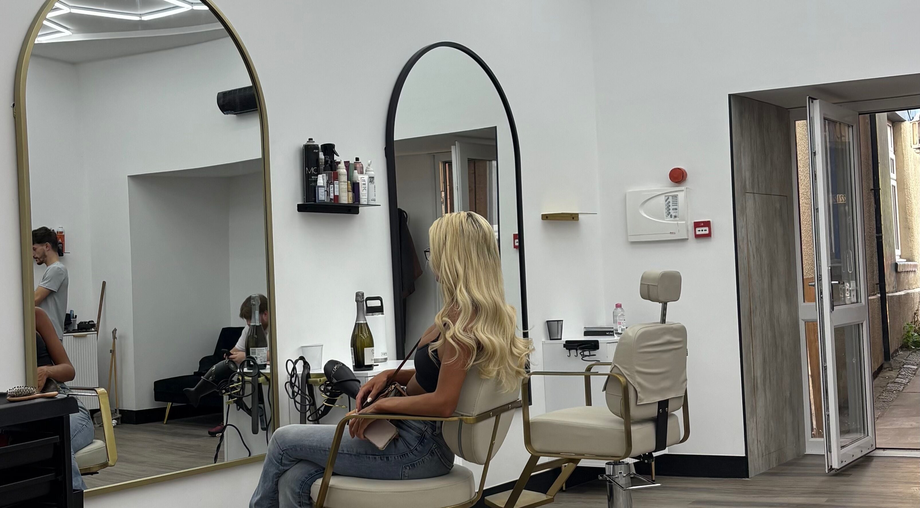 Maya The Hairstylist salon in Redditch, England, GB, showcasing modern styling chairs and sleek large mirrors.