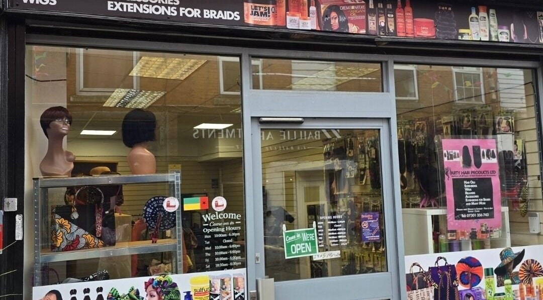 Exterior view of Arty beauty store in Rochdale, England, showcasing wigs and accessories in window.