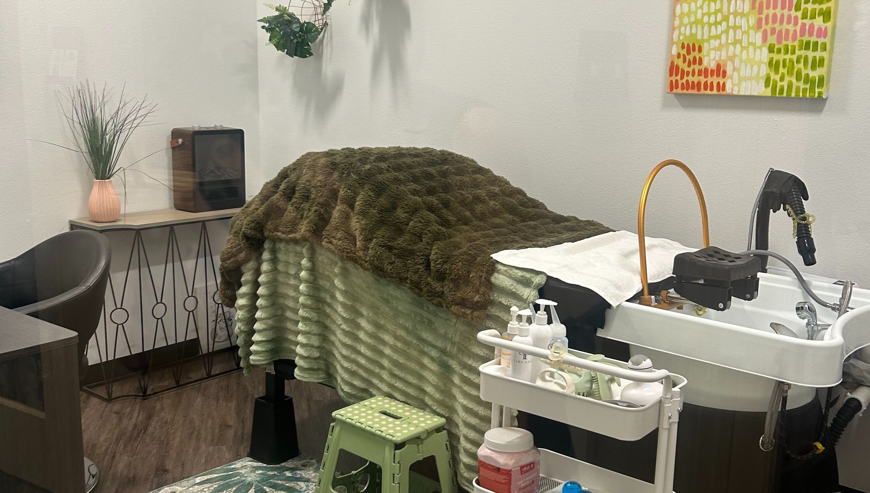 A relaxing treatment room at Rinse & Reset, Chattanooga, Tennessee, US with a plush blanket and wellness tools.