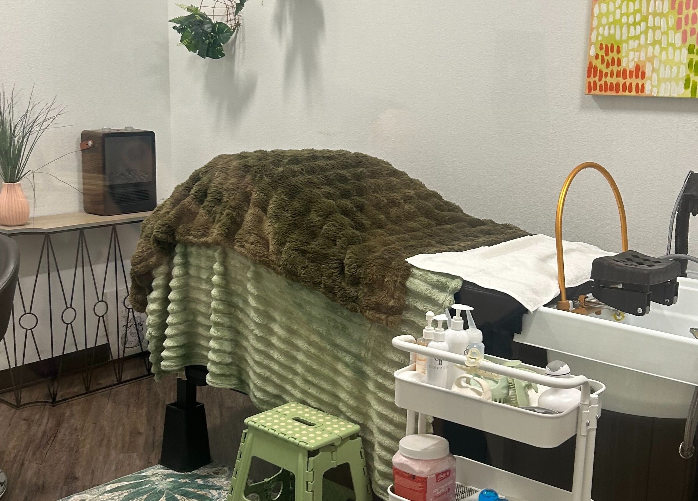 A relaxing treatment room at Rinse & Reset, Chattanooga, Tennessee, US with a plush blanket and wellness tools.