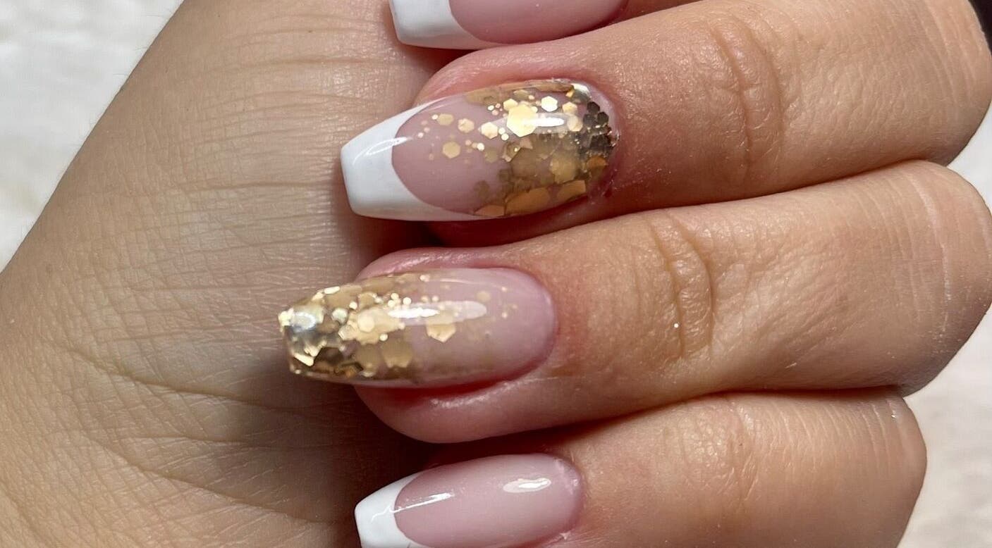 Design d'ongles élégant avec paillettes dorées chez AD Nails, Le Havre, Normandie, FR.