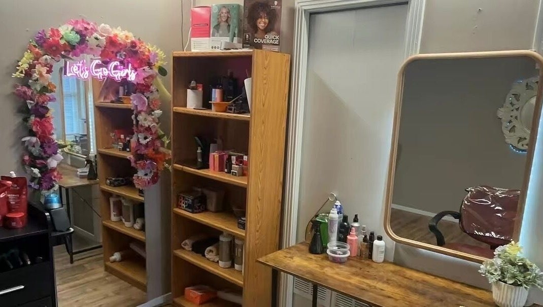 Área de maquillaje en Ferstylist By studio, Memphis, Tennessee, US, con espejo y decoración floral.