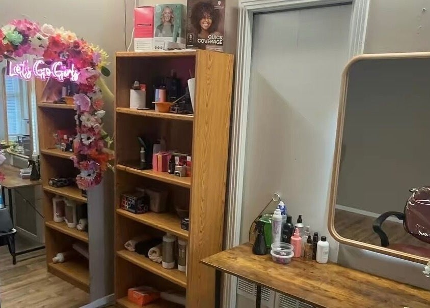 Área de maquillaje en Ferstylist By studio, Memphis, Tennessee, US, con espejo y decoración floral.