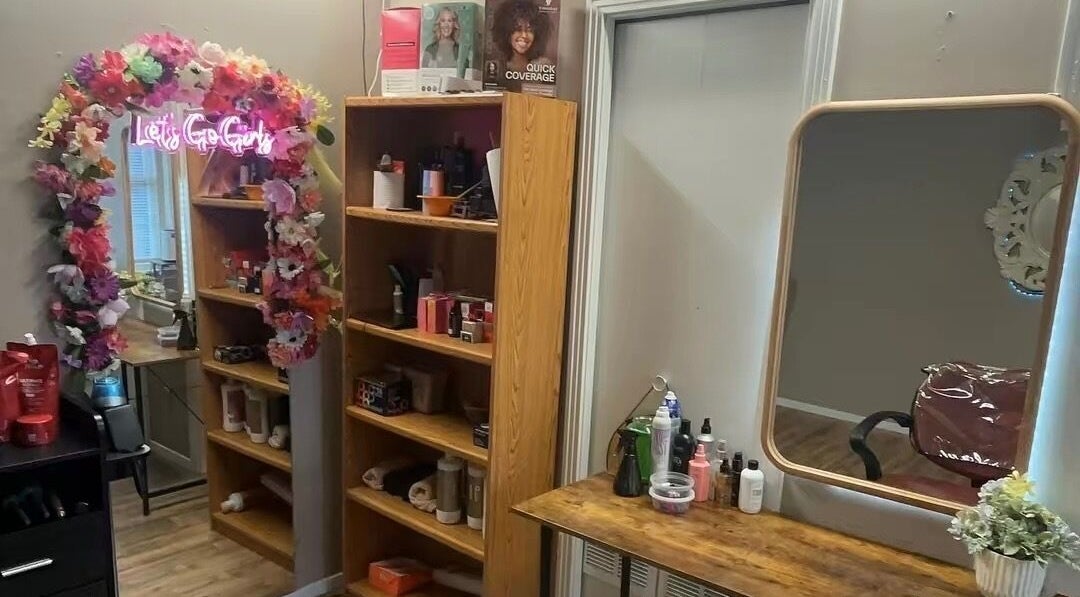 Área de maquillaje en Ferstylist By studio, Memphis, Tennessee, US, con espejo y decoración floral.