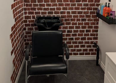 Modern salon chair and sink with brick wall at Mane Squeeze with Jacquie, Bowmanville, Ontario, CA.