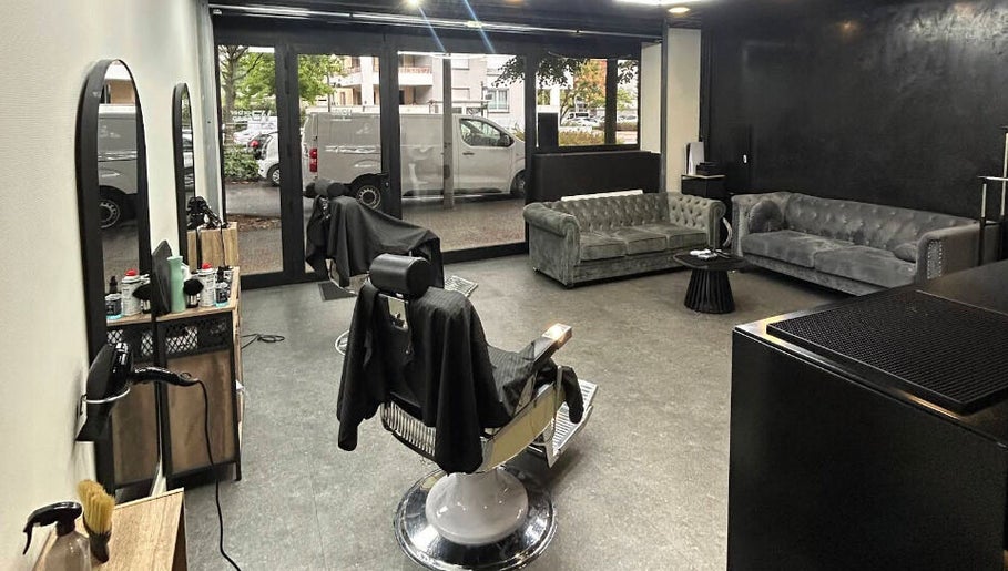Intérieur moderne du Wbarbershop à Échirolles, Auvergne-rhône-alpes, FR avec fauteuil et canapés.