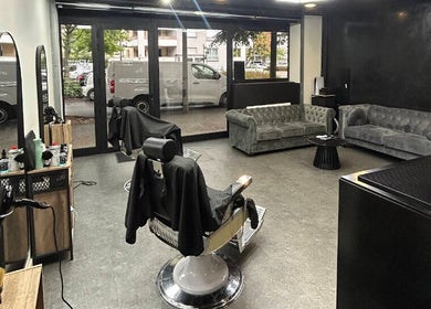 Intérieur moderne du Wbarbershop à Échirolles, Auvergne-rhône-alpes, FR avec fauteuil et canapés.
