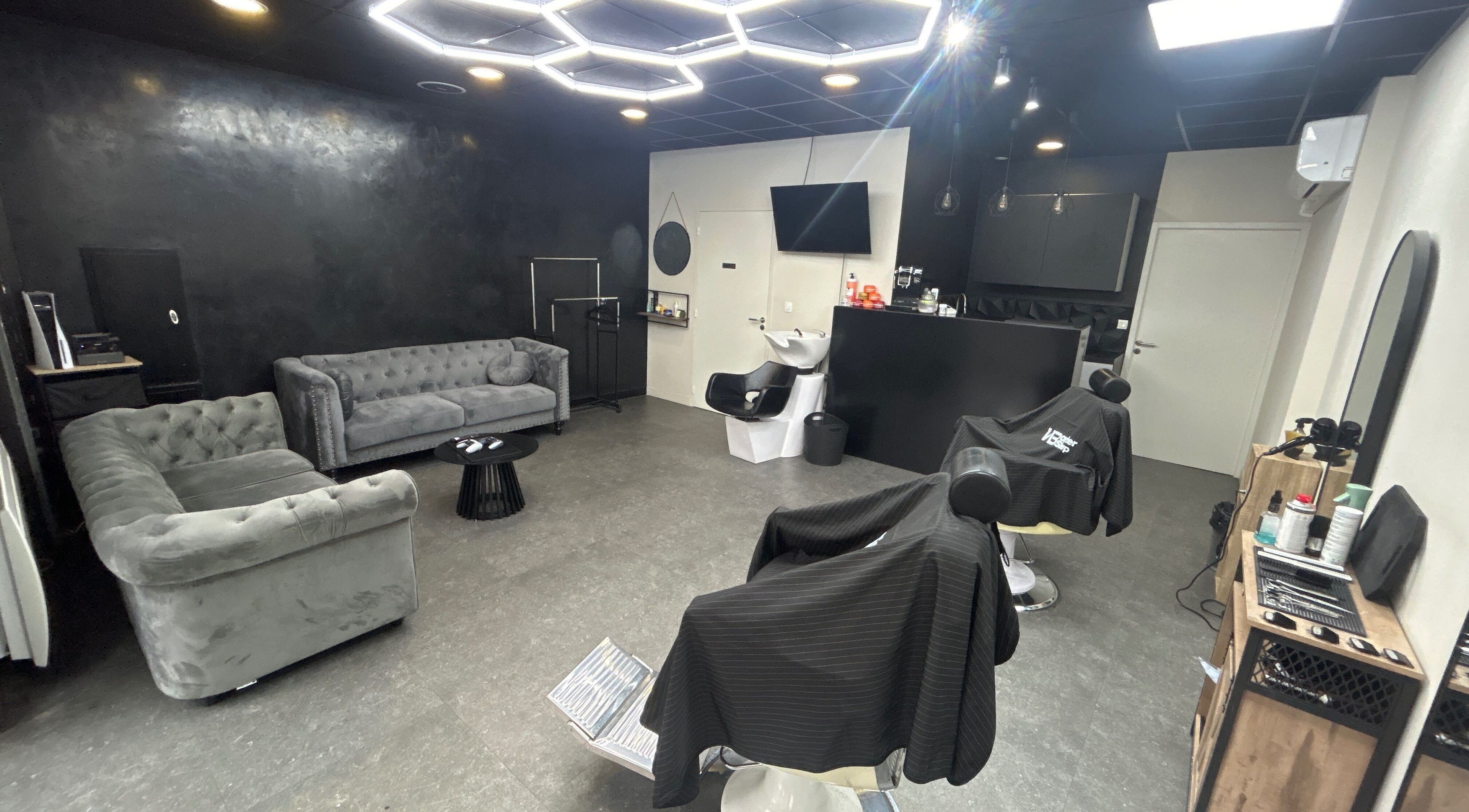 Intérieur moderne de Wbarbershop à Échirolles, Auvergne-rhône-alpes, FR avec canapés et fauteuils.