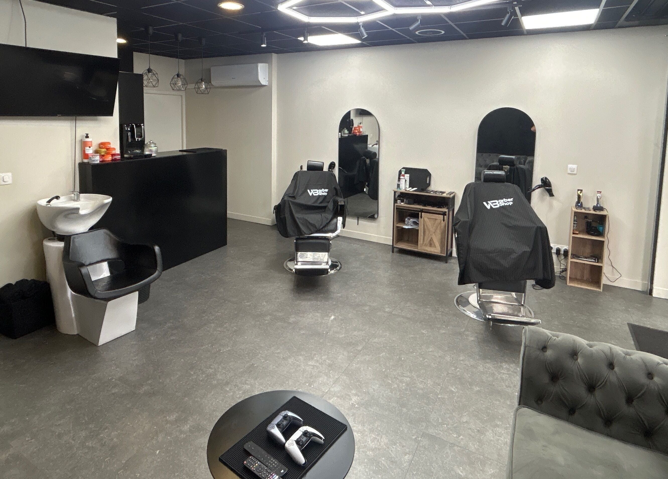 Intérieur moderne de Wbarbershop à Échirolles, Auvergne-rhône-alpes, FR avec fauteuils de coiffure noirs.