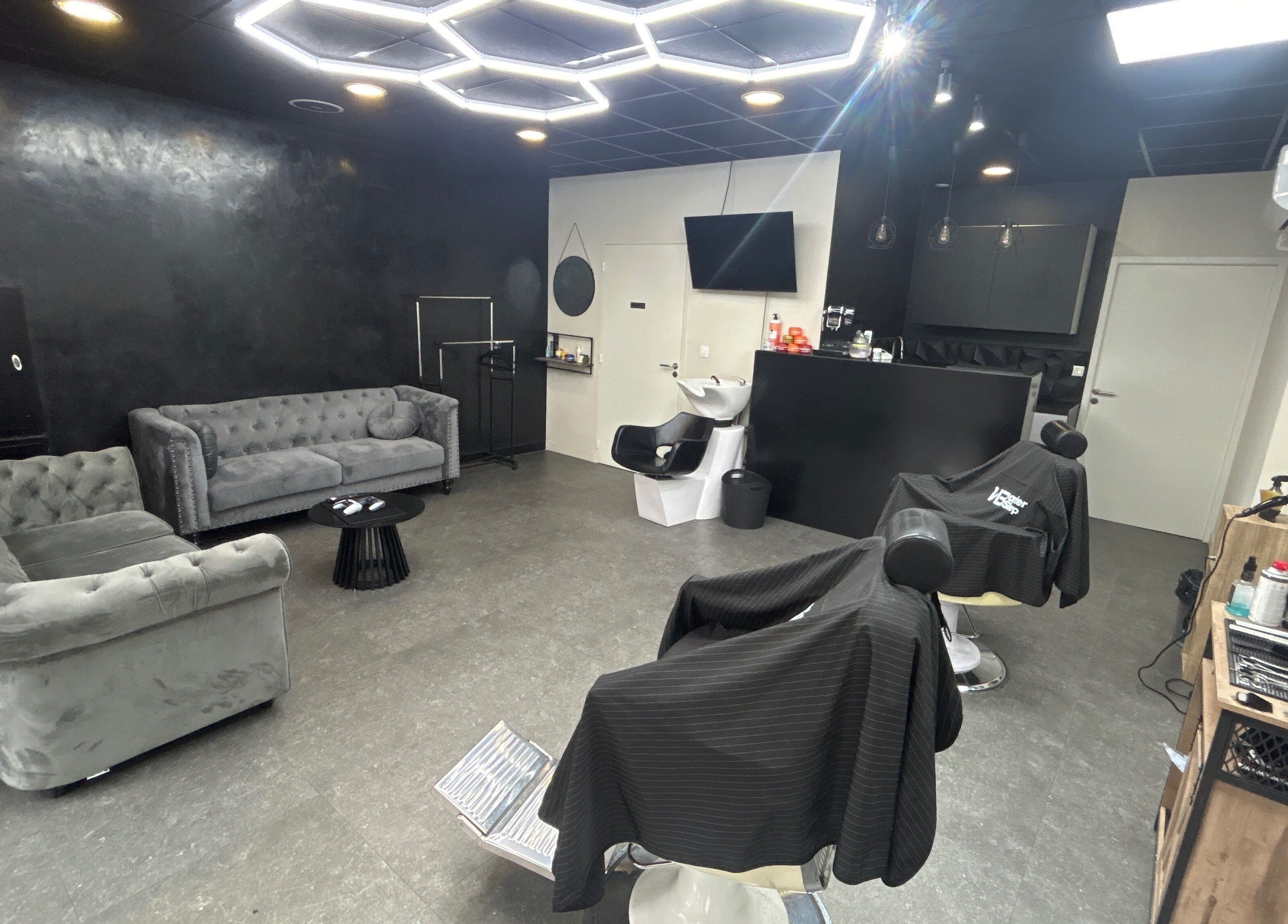 Intérieur moderne de Wbarbershop à Échirolles, design élégant et sièges confortables.