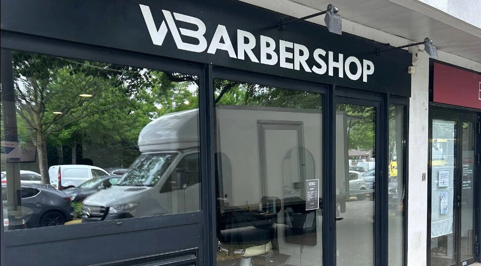 Entrée moderne de Wbarbershop à Échirolles, Auvergne-rhône-alpes, FR, reflétant la nature environnante.