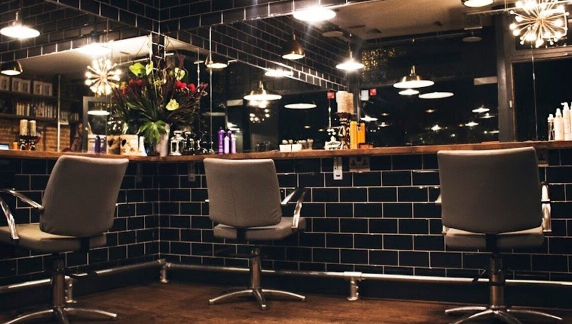 Modern hair salon at Jade @ Chandler & Hall, Southbourne, England, GB, with sleek chairs and stylish decor.