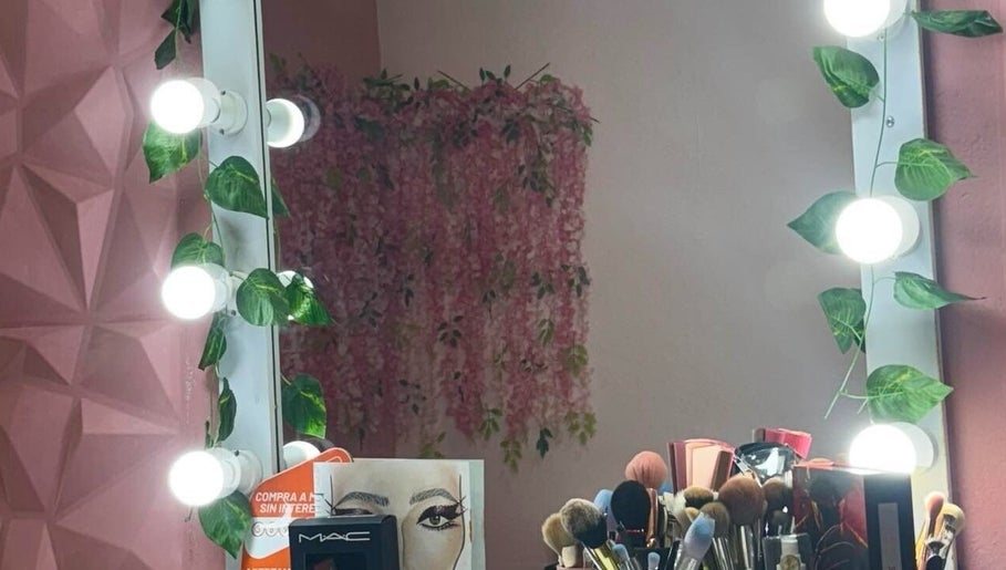 Espejo iluminado en Diana Sánchez Studio, Ciudad De México, MX. Decorado con hojas y maquillaje profesional.