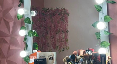 Espejo iluminado en Diana Sánchez Studio, Ciudad De México, MX. Decorado con hojas y maquillaje profesional.