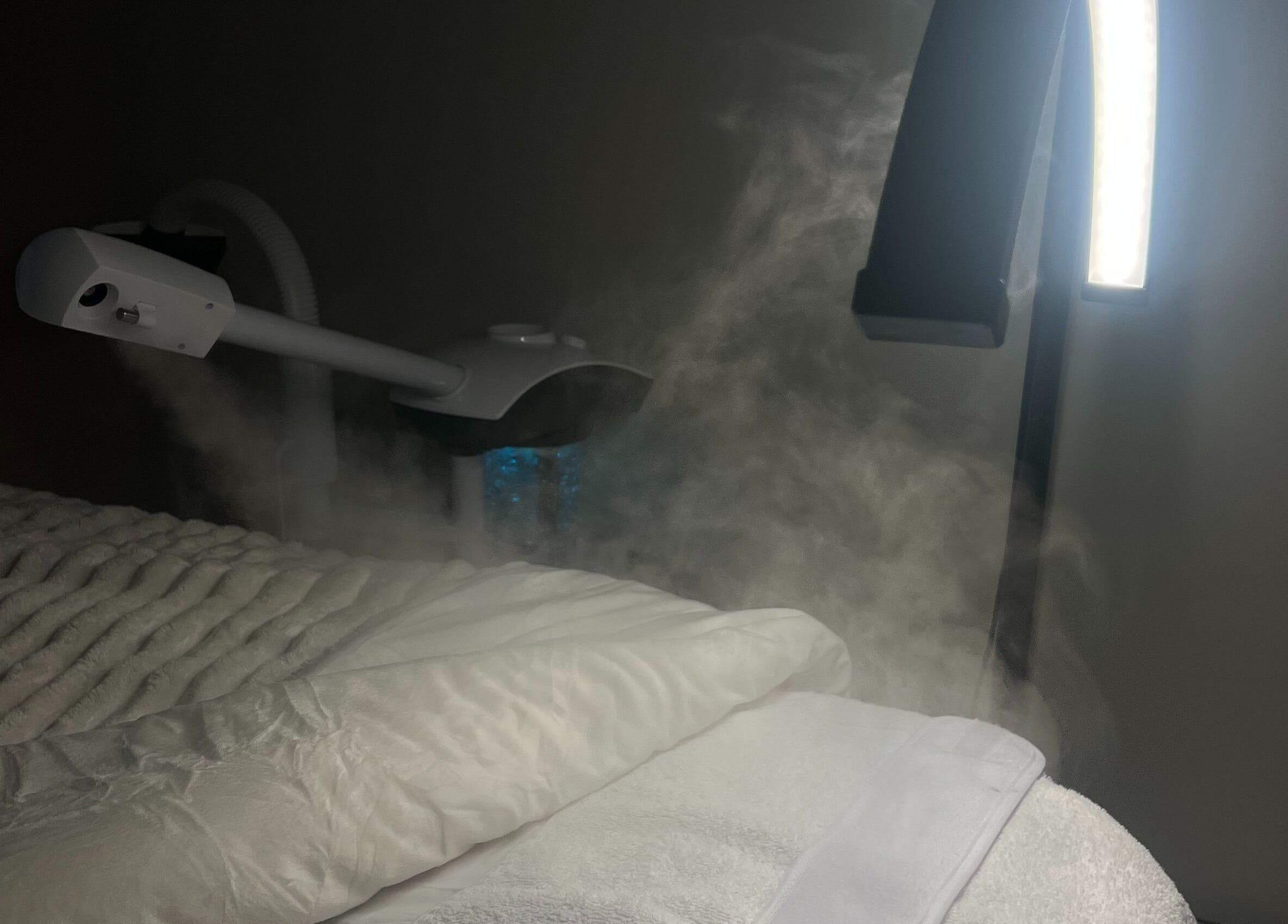 Luxurious spa bed with facial steamer at Glow Essence Beauty in Vaughan, Ontario, CA.