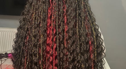 Intricate braided hairstyle at Naomiscrownedtouch, London, England, GB, showcasing red and gold accents.