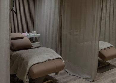 Tranquil treatment room at Queen B Beauty, Newhaven, England, GB, with cozy massage tables and curtains.