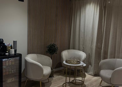 Elegant seating area at Queen B Beauty, Newhaven, England, GB, featuring chic chairs and a coffee station.