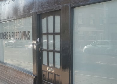 Entrance of Rudders & Rubdowns Male Massage Spa in Lowestoft, England, GB showcasing modern glass design.