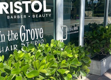 Exterior view of Bristol Haircare at Delray Beach, Florida, US with lush greenery and glass windows.