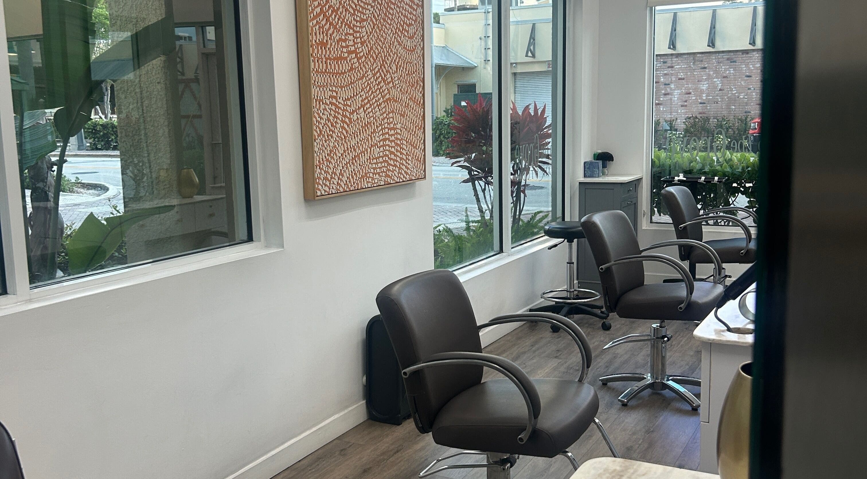 Modern salon chairs at Bristol Haircare, Delray Beach, Florida, US, with vibrant artwork and street view.