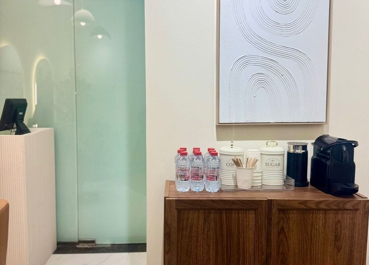 Blowbar ladies Saloon's refreshment area in Dubai, Dubai, AE, featuring a coffee machine and water bottles.