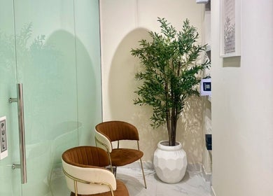 Stylish seating area at Blowbar Ladies Saloon, Dubai, Dubai, AE with modern chairs and a decorative plant.