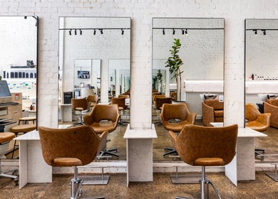 Modern salon interior at Bespoke Hair, Fortitude Valley, Queensland, AU with stylish chairs and large mirrors.