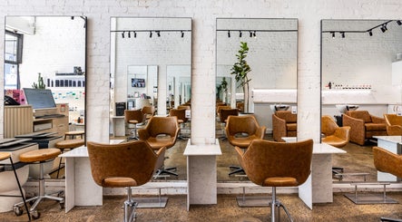 Modern salon interior at Bespoke Hair, Fortitude Valley, Queensland, AU with stylish chairs and large mirrors.