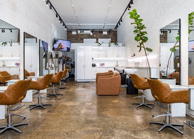 Chic salon interior of Bespoke Hair in Fortitude Valley, Queensland, AU showcasing stylish chairs and large mirrors.