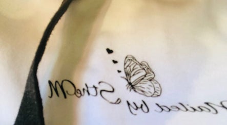 Close-up of NailedbyStheM logo with a butterfly design, Soweto, Gauteng, ZA.