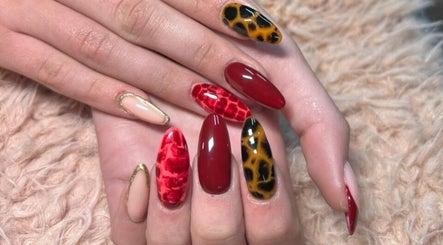 Detailed nail art at Bloom & Thrive Beauty, Parys, Free State, ZA. Red and gold nail designs create a dynamic look.