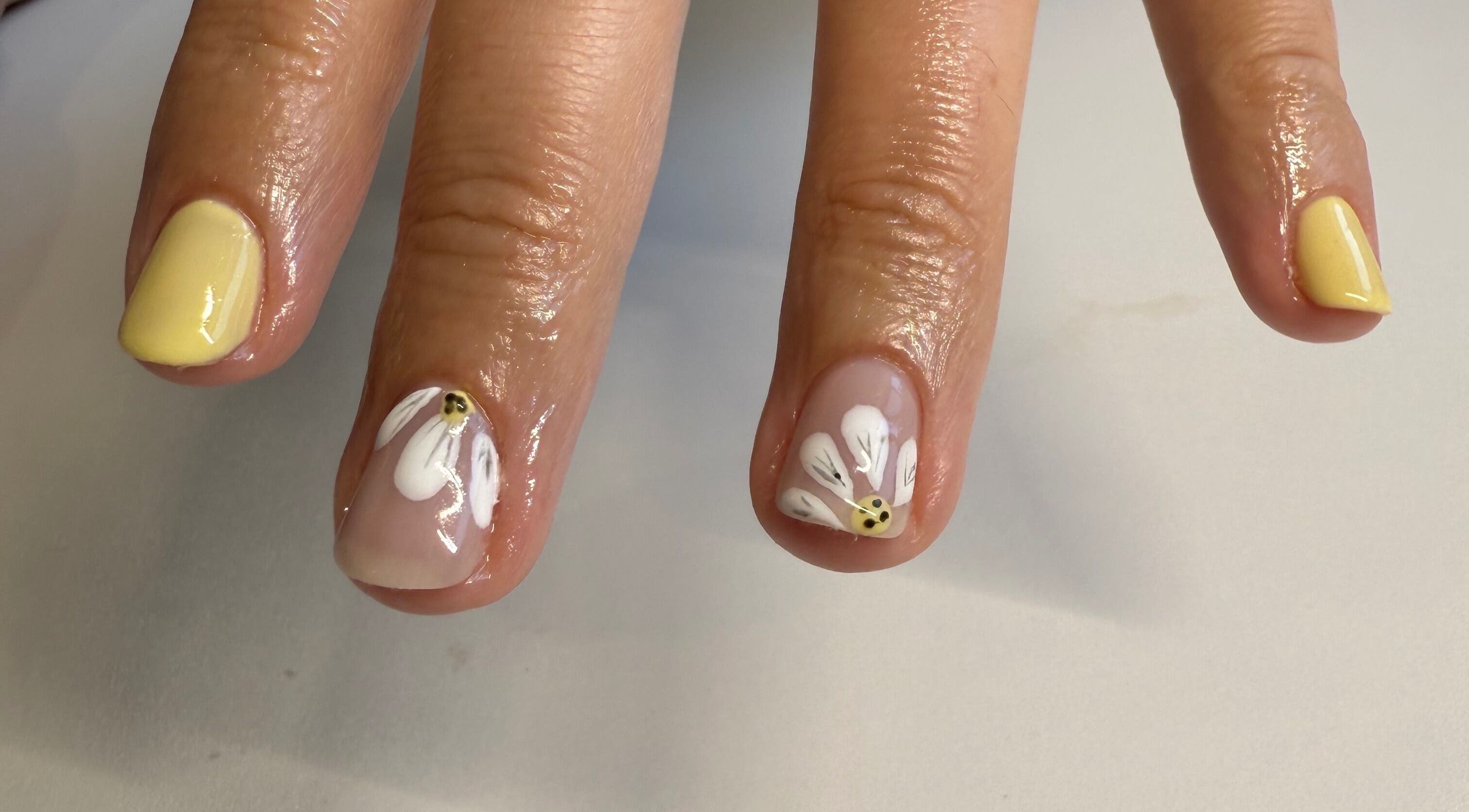 Elegant floral nail art at Esthetics by Sydney, South Glengarry, Ontario, CA. Vibrant yellow and white design.