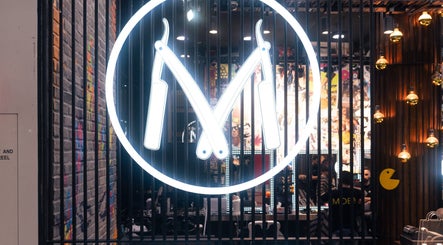 Neon barber logo at Moe & Co West Gosford, New South Wales, AU with vibrant interior decor.