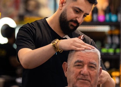 Professional barber at Moe & Co West Gosford grooming a client's hair in West Gosford, New South Wales, AU.
