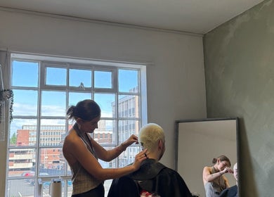 Hairstylist working on a client at SHADE TWENTY2, Wolverhampton, England, GB, natural light through large windows.