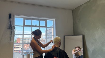 Hairstylist working on a client at SHADE TWENTY2, Wolverhampton, England, GB, natural light through large windows.