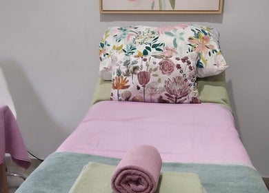 Relaxing bed setup at Blomelle Aesthetics, Pretoria, Gauteng, ZA, featuring floral and pink decor.