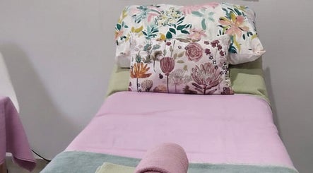Relaxing bed setup at Blomelle Aesthetics, Pretoria, Gauteng, ZA, featuring floral and pink decor.