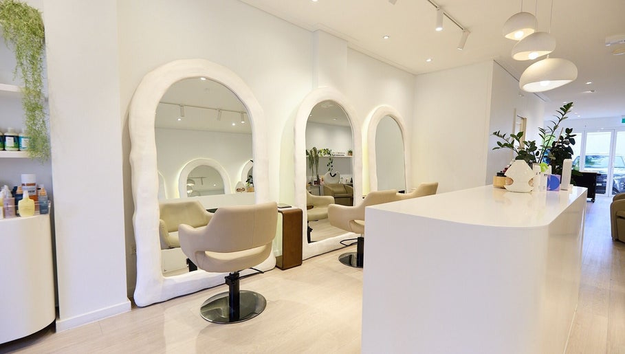 Modern interior of Hair by Rhie, Surry Hills, NSW, AU featuring stylish salon chairs and elegant mirrors.