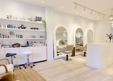 Chic, modern salon interior of Hair by Rhie in Surry Hills, New South Wales, AU, featuring plush seating and mirrors.