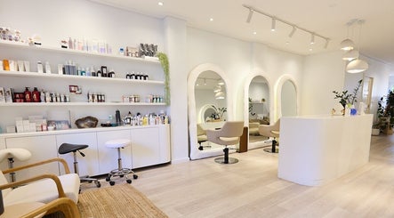 Chic, modern salon interior of Hair by Rhie in Surry Hills, New South Wales, AU, featuring plush seating and mirrors.